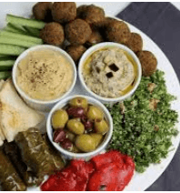 Greek platter with olives, hummus, falafel, celery, and dolmas.