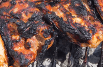 A picture of charred meat being grilled.