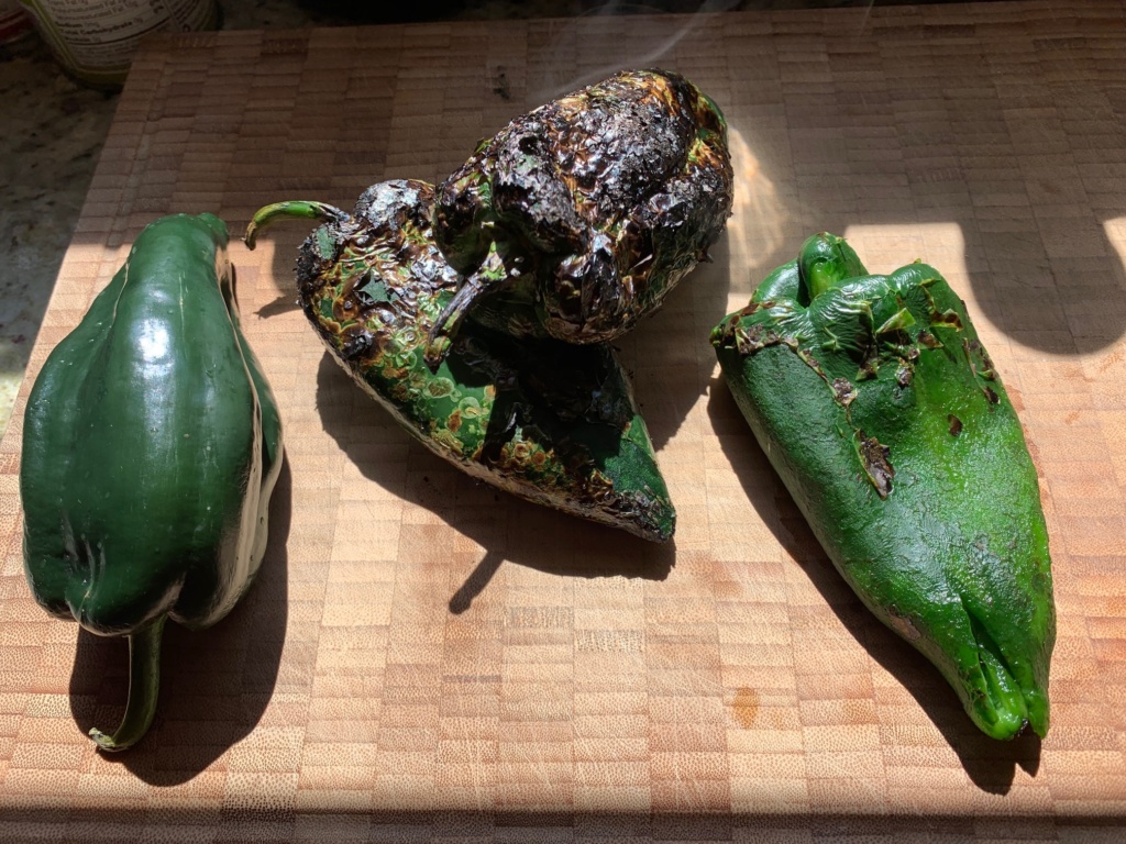 Picture of a poblano, grilled and charred poblano and a poblano without its skin.