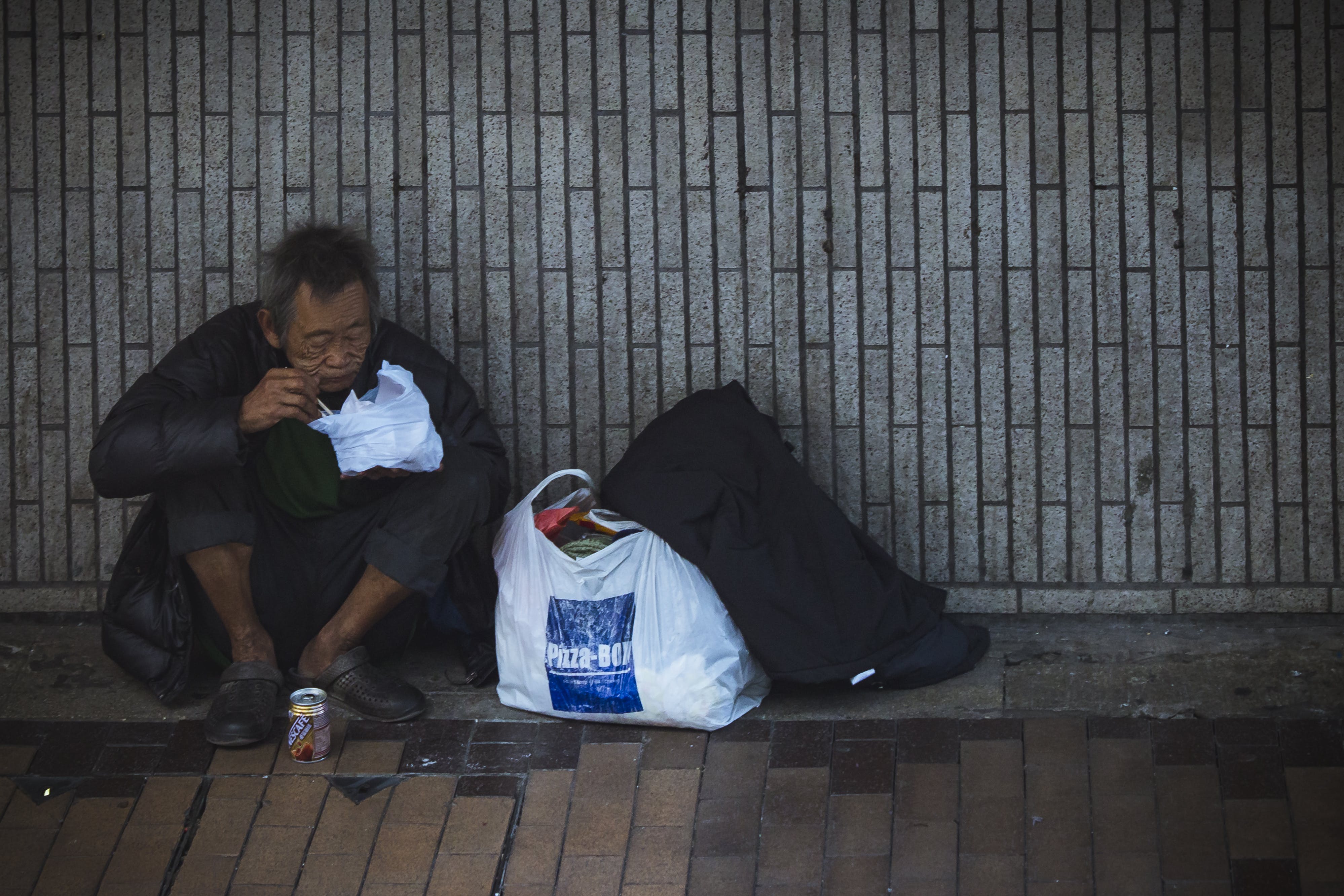 Man Sitting Beside Wall