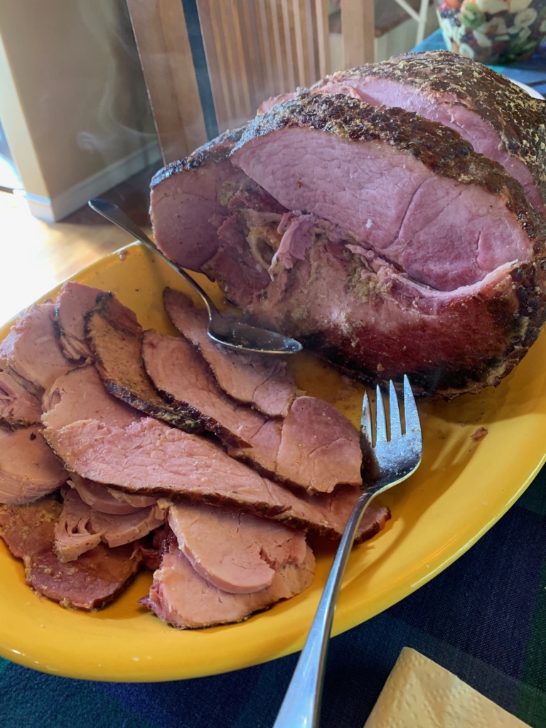 Baked spiral ham served one night, sitting on a yellow serving platter.