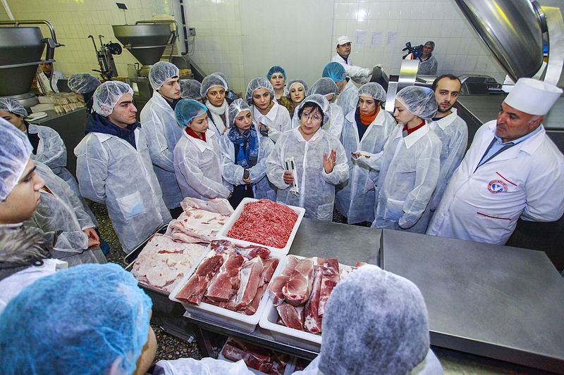 A photo of students around batches of meat