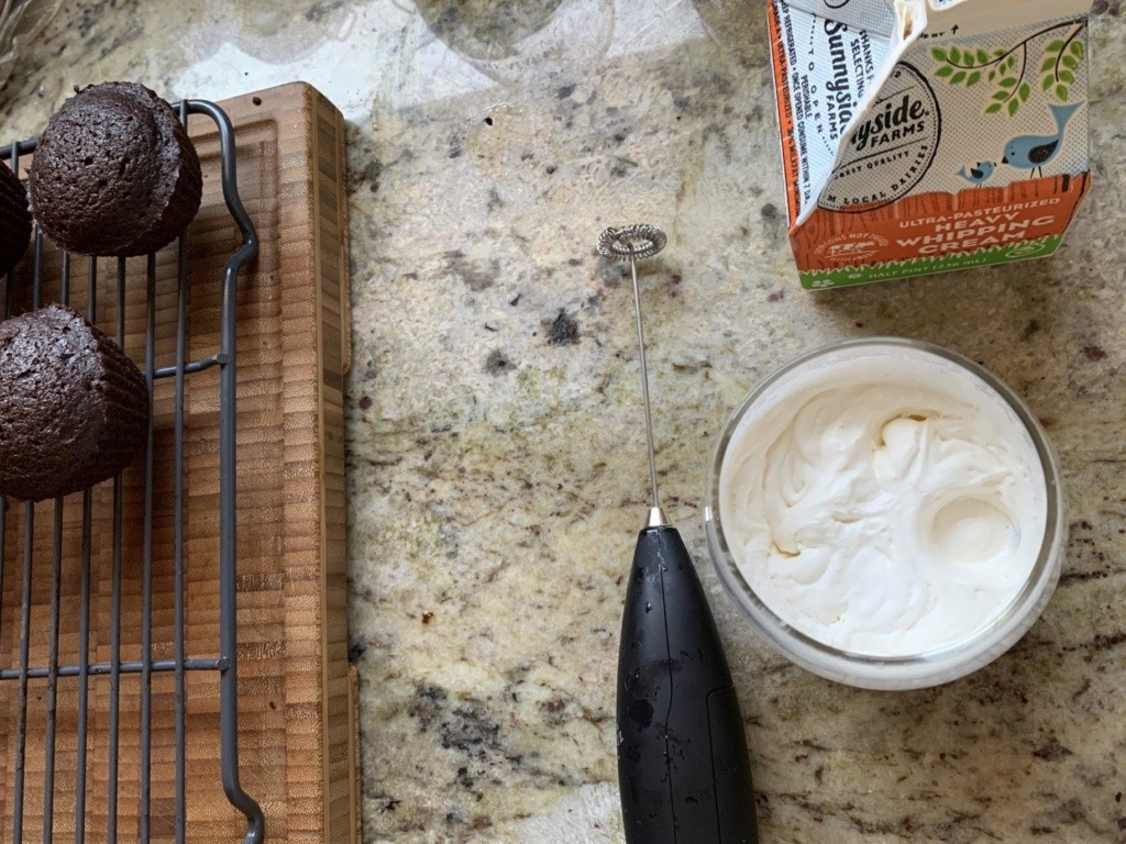 Photo of whipped cream and chocolate cup cakes.