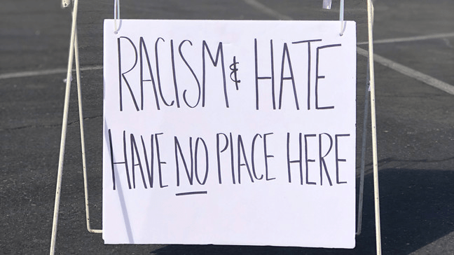 A photo of a sign at a farmers market indication no racism or hate.