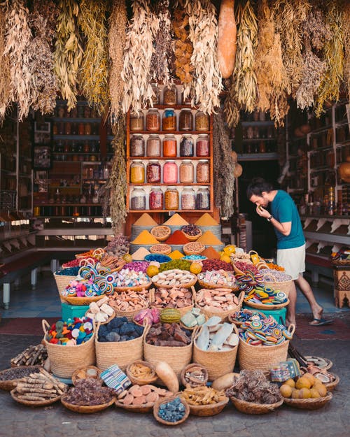 Picture of a man sniffing spice in an outdoor market.