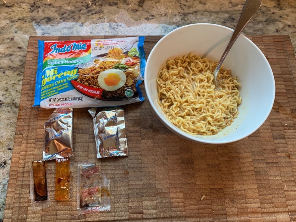 This photo shows the noodle packaging, 5 ingredient packs, and one bowl of noodles.