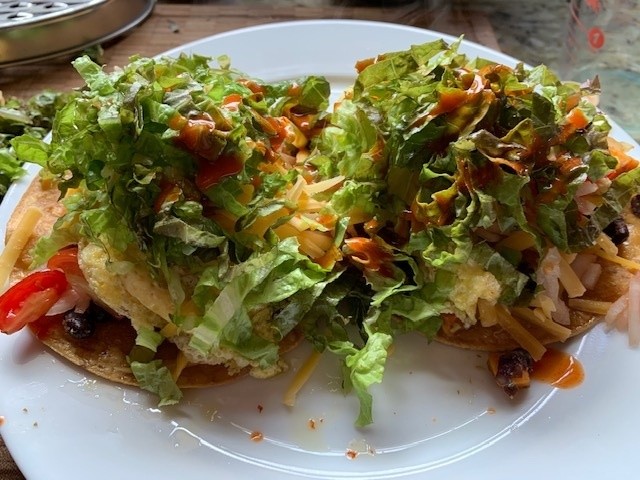 A photo of a plate with two veggie tacos on them.