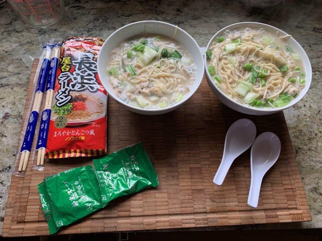 A photo of the soup packaging, two bowls of what I made with chopsticks and spoons.