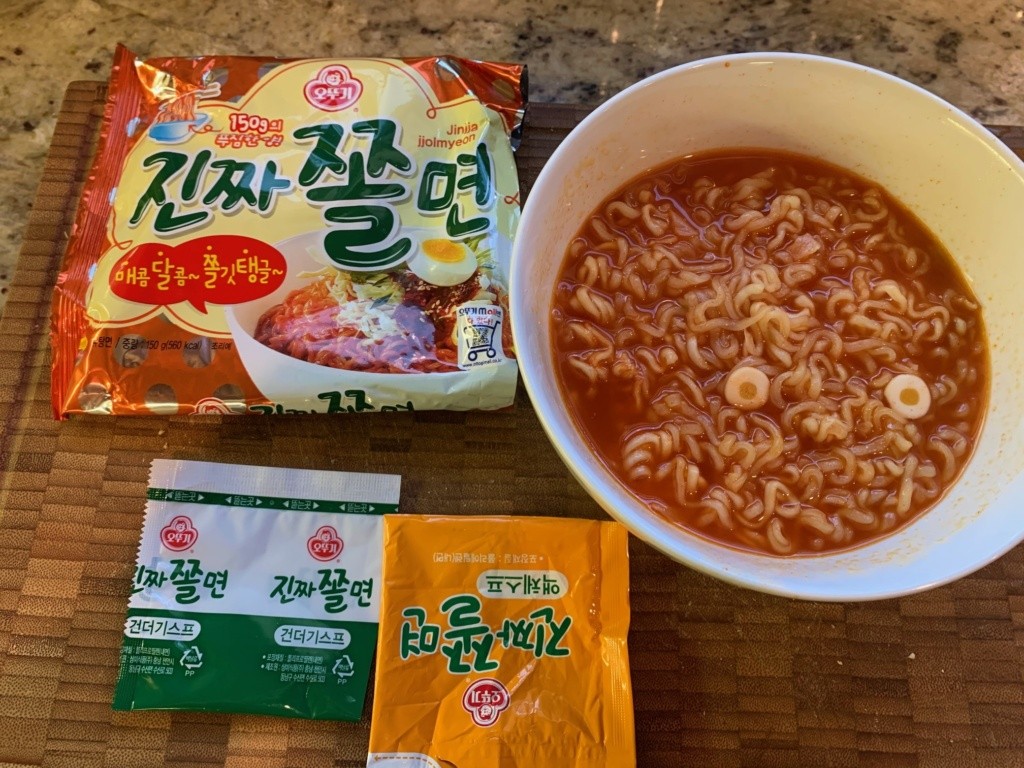 Photo of the noodle packaging and a bowl of noodles a bit too soupy.