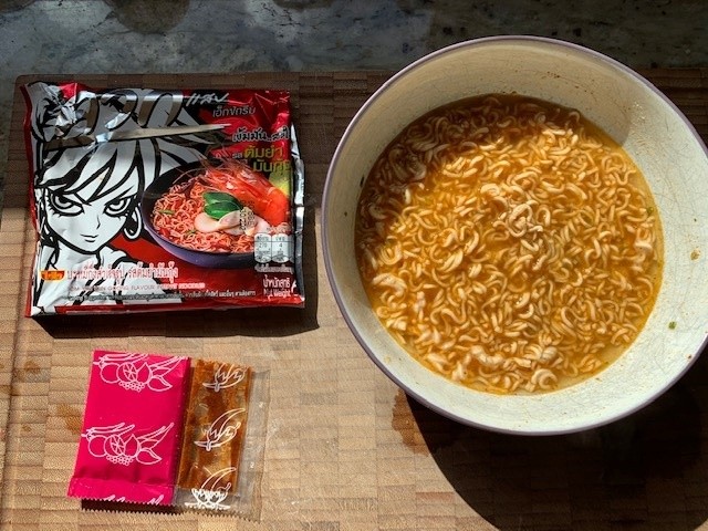 Bowl of noodles, packaging and packets.