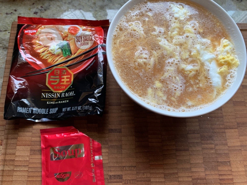 Photo of ramen soup packages, with a bowl of soup with an added egg.