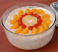 An ambrosia salad prepared for a potluck topped with canned mandarin orange slices, maraschino cherries, and a canned pineapple ring.