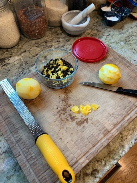 A picture of making lemon pepper with a zester, knife, and lidded bowl.