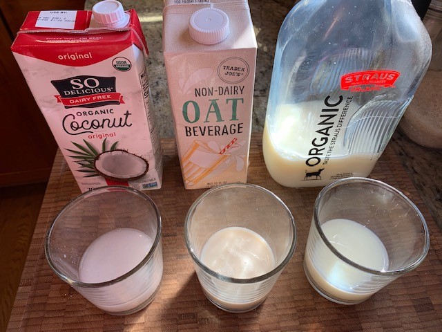 A picture comparing coconut, oat and cows milk.