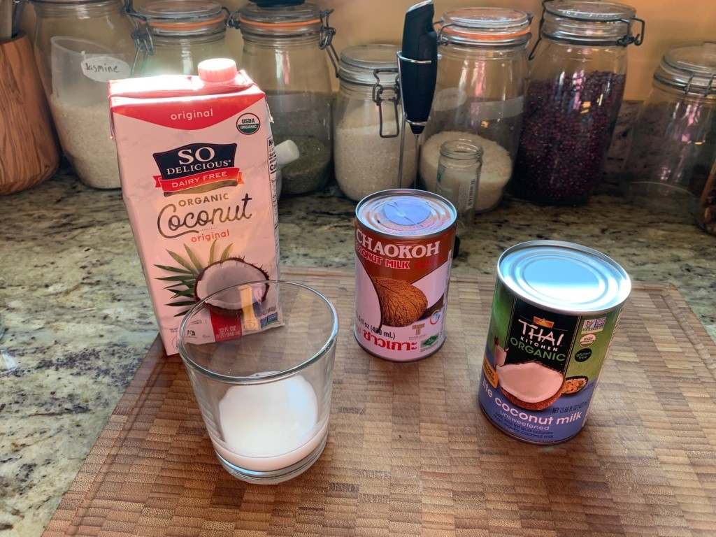 A picture of drinkable coconut milk, and two cans of cooking coconut milks.