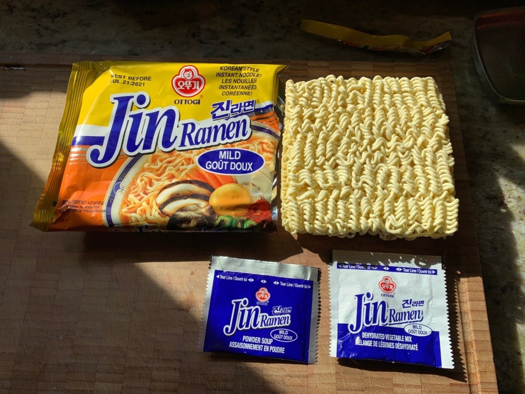 Photo of the packaging, a bowl showing the square noodle puck, and the packets of broth and flavors.