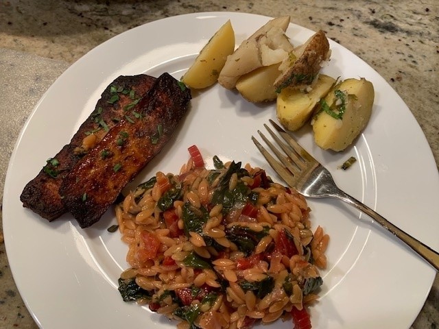 A meal with grilled marinated tofu, herbed baked potatoes, and a rice-chard dish.