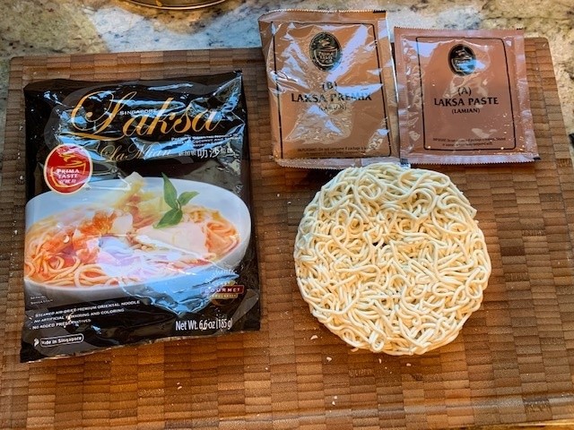 Photo of the packaging, a bowl showing the round noodle puck, and the packets of broth and flavors.