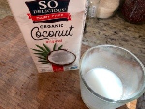 Photo of a coconut container and glass of the milk.