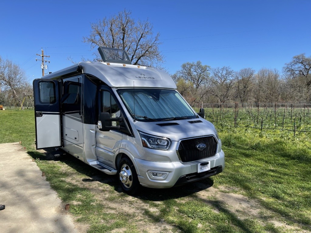 Our RV parked in their one spot on the farm with vineyards in the background.