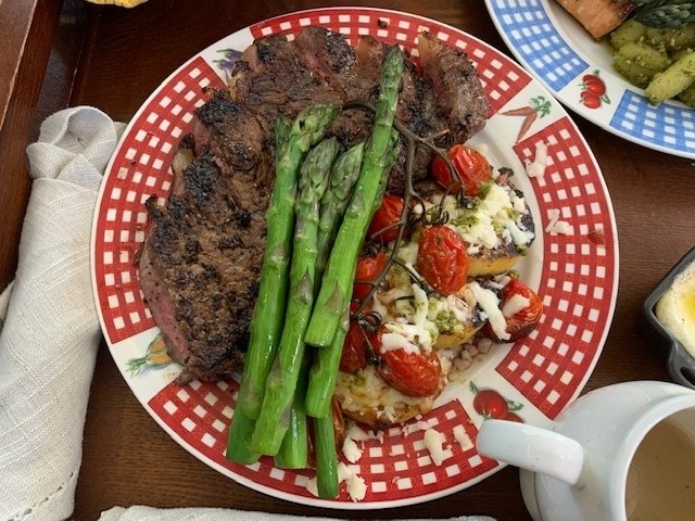 Wagu steak dinner on a red checkered plate. Very colorful plate of food with green reds, white and browns