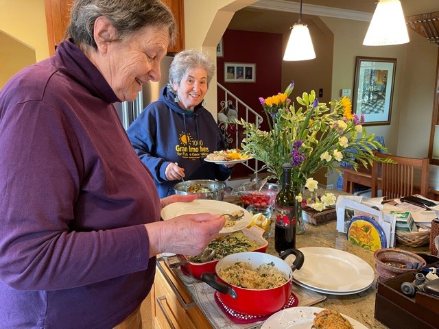 Photo of Eva and Rochelle serving themselves dinner.